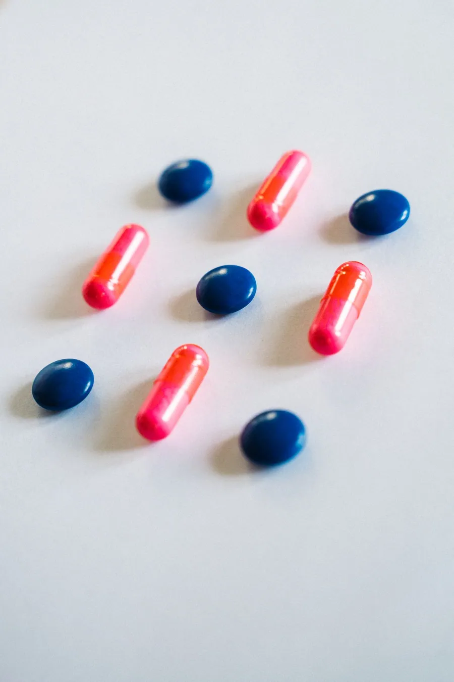 A hand holding tablets beside a medication bottle